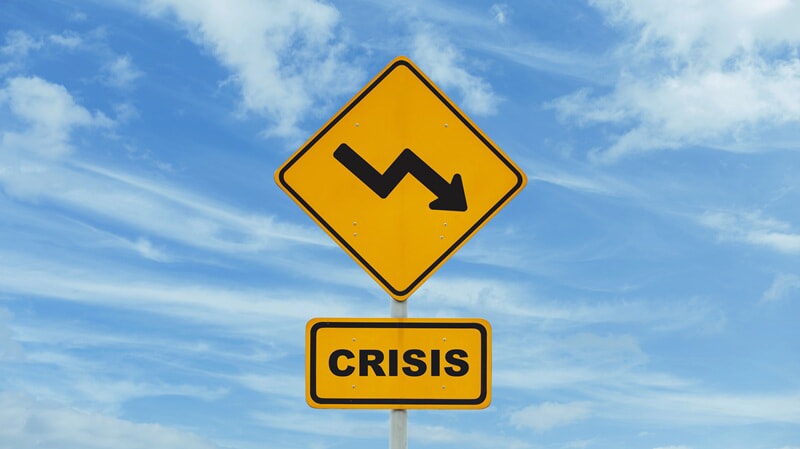 An image of a yellow outdoor crisis sign with an arrow that zig-zags and points down.